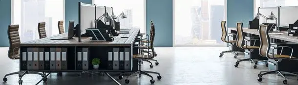 A row of office chairs in front of a desk.